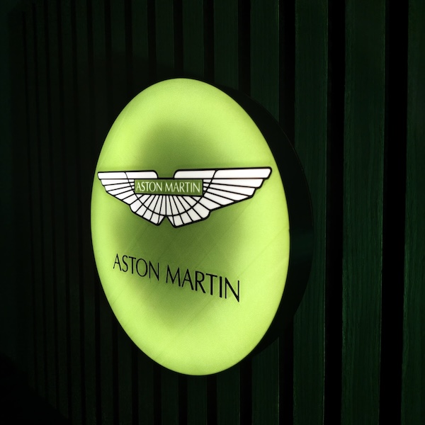 Beleuchtete Aston Martin LED-Lampe in grün an der Wand mit farblicher Ambiente-Beleuchtung