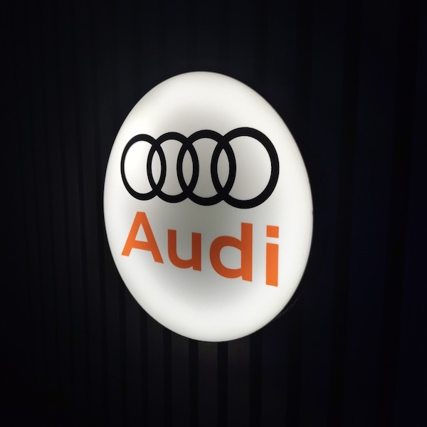 Beleuchtete AUDI LED-Lampe in schwarz weiß rot an der Wand mit farblicher Ambiente-Beleuchtung