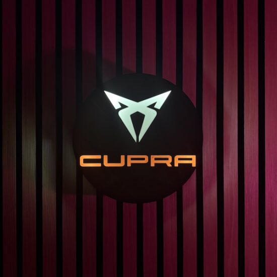 Beleuchtete CUPRA Logo LED-Lampe in schwarz weiß rot an der Wand mit farblicher Ambiente-Beleuchtung