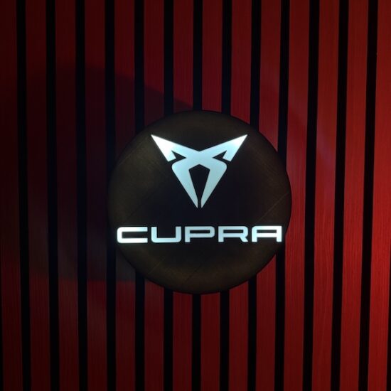 Beleuchtete CUPRA LED-Lampe in schwarz weiß an der Wand mit farblicher Ambiente-Beleuchtung