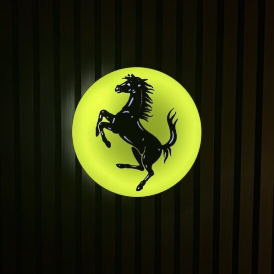 Beleuchtete Ferrari Logo LED-Lampe in gelb schwarz an der Wand mit farblicher Ambiente-Beleuchtung