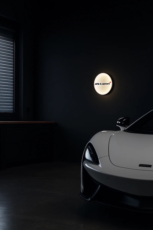 Runde McLaren Logo LED-Leuchte beleuchtet in einer dunklen Garage / Werkstatt