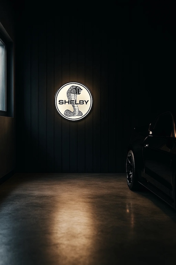 Runde Shelby Cobra Logo LED-Leuchte beleuchtet in einer dunklen Garage / Werkstatt