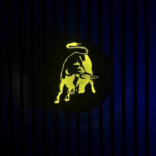 Beleuchtete Lamborghini Stier Logo LED-Lampe in schwarz gelb an der Wand mit farblicher Ambiente-Beleuchtung