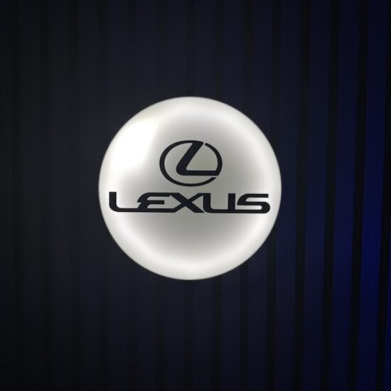 Beleuchtete Lexus Logo LED-Lampe in schwarz weiß an der Wand mit farblicher Ambiente-Beleuchtung