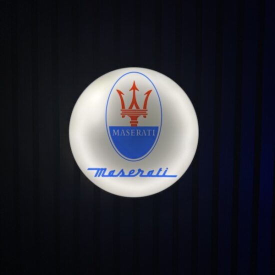 Beleuchtete Maserati Logo LED-Lampe in Farbe an der Wand mit farblicher Ambiente-Beleuchtung