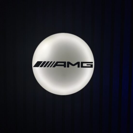 Beleuchtete AMG Logo LED-Lampe in schwarz weiß an der Wand mit farblicher Ambiente-Beleuchtung