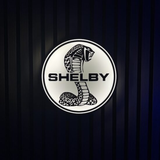Beleuchtete Shelby Cobra Logo LED-Lampe in schwarz weiß an der Wand mit farblicher Ambiente-Beleuchtung