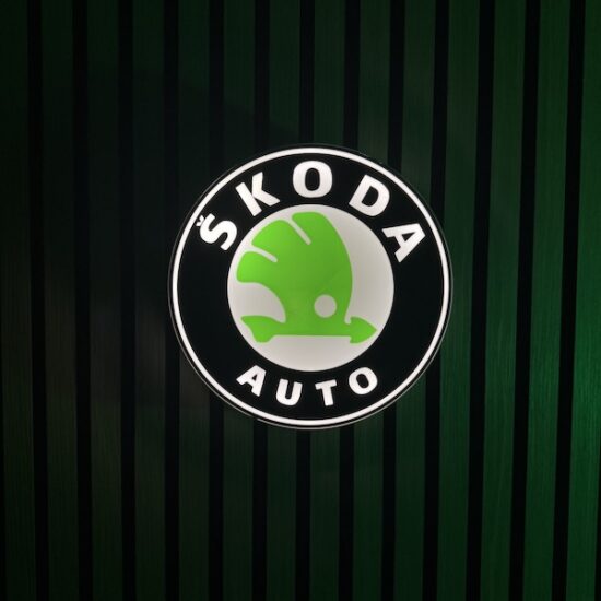 Beleuchtete Skoda Logo LED-Lampe in blau weiß grün an der Wand mit farblicher Ambiente-Beleuchtung